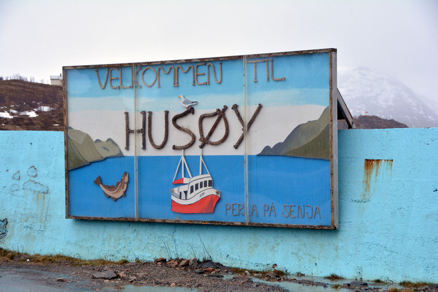 'Welcome to Husøy' on Senja Island. Husøy with its snow, sleet, steep road, tunnel and drying fish heads with hooded crows perched above them seemed like the inhospitable end of the world after driving too many miles in foul weather.