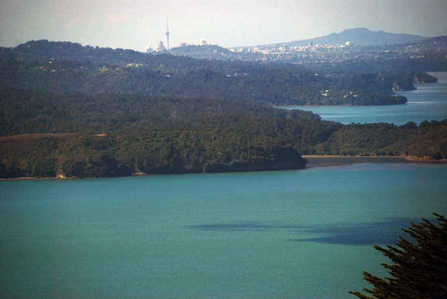 Auckland from the south west at Awhitu Lighthouse on the south side of the Manukau Harbour entrance lloking over the Manukau and the wooded north shore of the habour as it descends from the Waitakere Ranges.