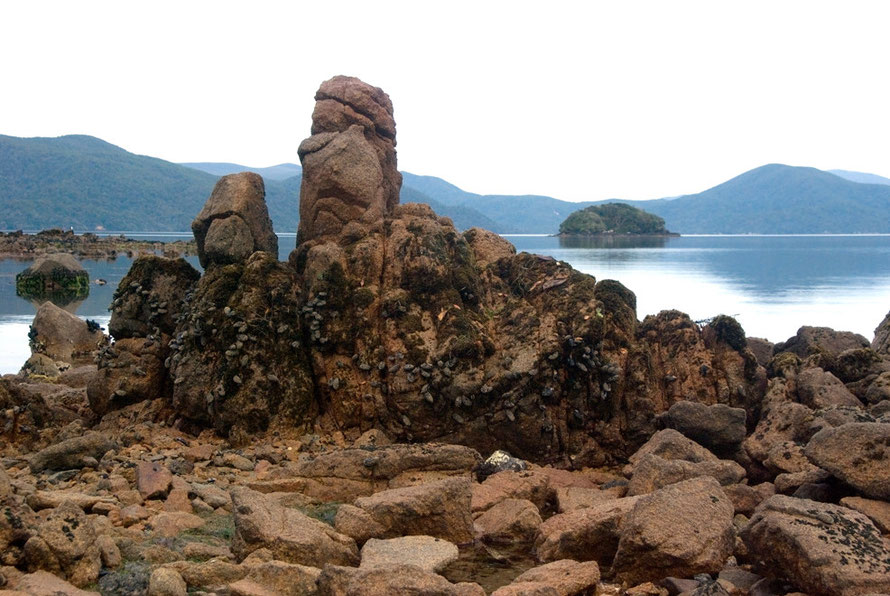 Stewart Island is made up of intrusive granite, much of which is weathered and rotten - these formations are on Boulder Beach, Ulva with Tamihau Island and the rounded hills of the 'mainland' in the b