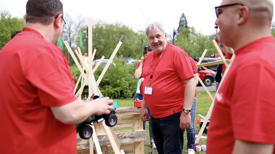 Teambuilding für Unternehmen — Team baut gemeinsam eine Kettenreaktion bei einem Outdoor-Event
