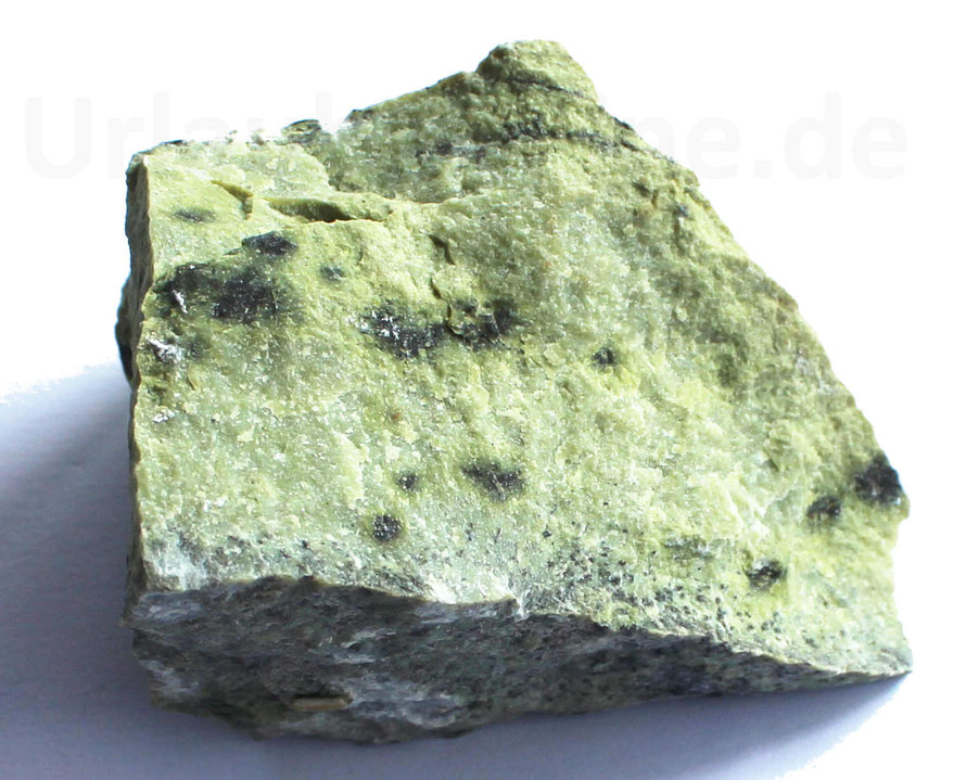 Grüner Stein mit schwarzen Punkten (EInschlüssen).