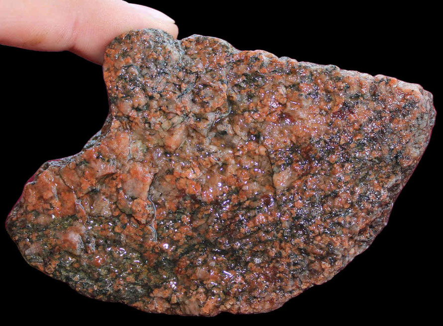 Rötlicher Granit mit deutlichen Feldspatkristallen.