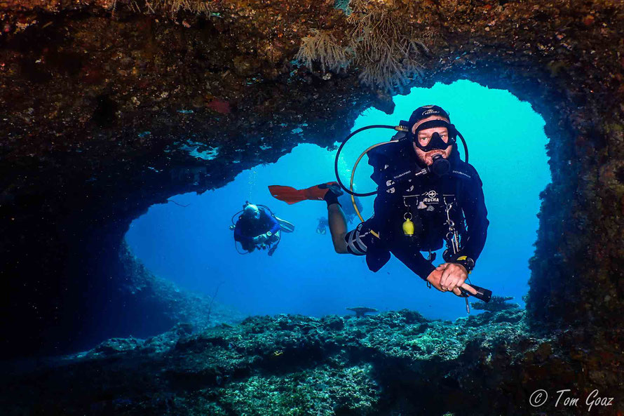 Famous Dive Site in El Nido, Palawan, Philippines. Scuba Diver swimming into an underwater cave. Cavern Diving.