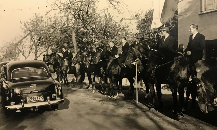 Die Ankunft des Bischofs wurde hier in den 50er Jahren mit Pferden von Dorfbewohnern vor der Bäckerei Gödde begrüßt und zur Kirche geleitet. Im Hintergrund rechts sieht man das damalige Miederwaren Geschäft Spieker. 