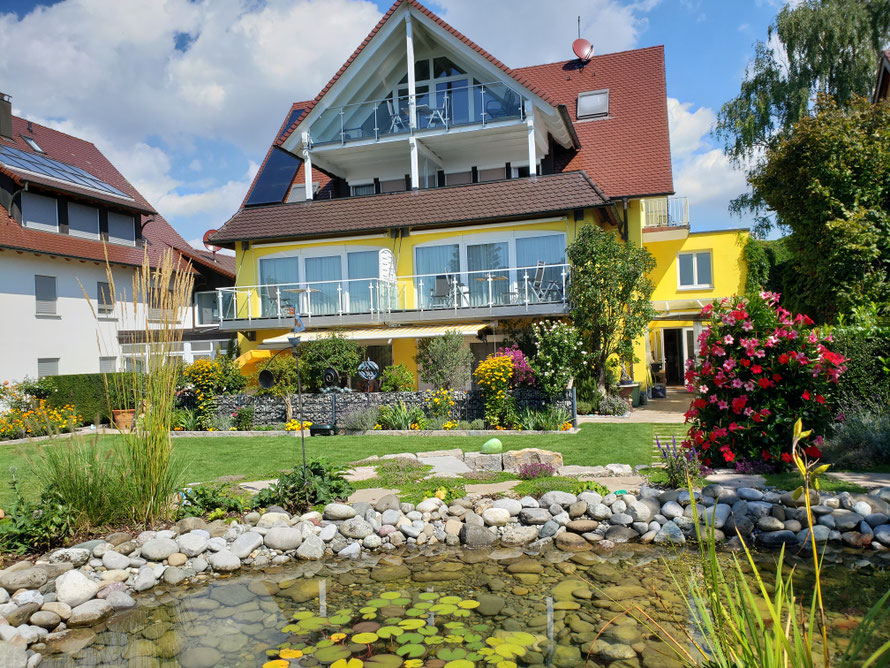 "Vorderansicht vom Haus Melanie mit Gartenteich und Wiese im Vordergrund"