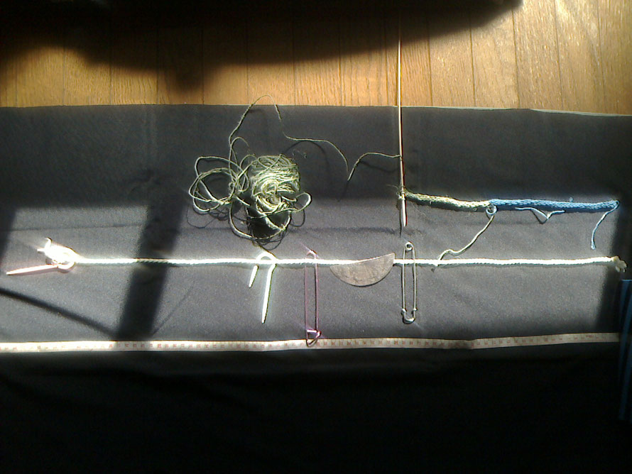 今まで編んだ紐と、メジャーを一緒に置いてみました。