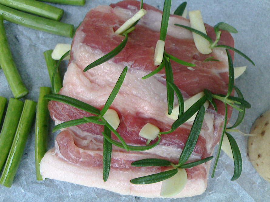 生の豚固まり肉に、ローズマリーとニンニクチップを差し込み、
