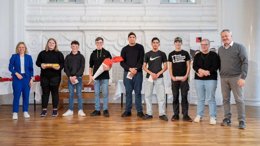 Fünf Schüler und zwei Schülerinnen der Klasse 9 stehen auf der Bühne. Zwei Vertreter der Würth Bildungsstiftung stehen rechts und links neben den Schülern.
