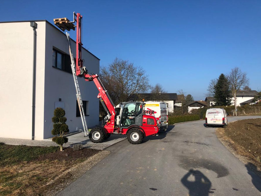 Betriebseigener Hoftrac mit Staplerturm und moderner Hebebühne - Wir bringen Ihre PV-Module sicher, schnell und flexibel auf jede nötige Dachhöhe.