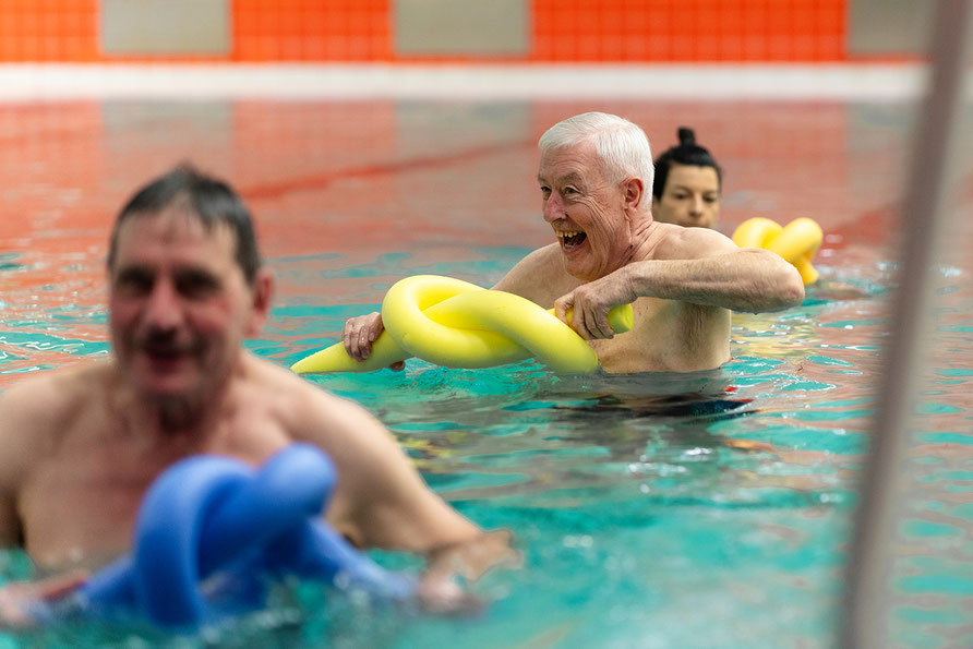 Teilnehmende der BSV Achim Aquafitness-Sport-Gruppe trainieren mit Poolnudeln im Wasser und fördern Kraft sowie Beweglichkeit.
