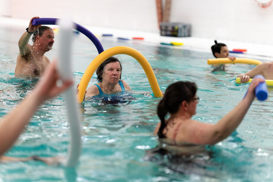 Teilnehmende der BSV Achim Wassergymnastik-Reha-Sport-Gruppe trainieren im Wasser mit Poolnudeln zur Verbesserung von Beweglichkeit und Ausdauer.