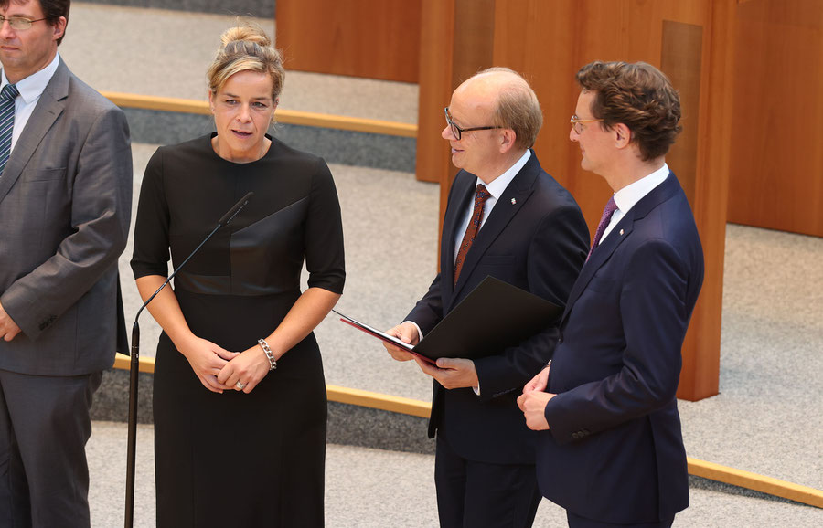 Landtagspräsident André Kuper (M.) und Ministerpräsident Hendrik Wüst bei der Vereidigung der grünen Wirtschaftsministerin Mona Neubaur. (Quelle: Bildarchiv des Landtags Nordrhein-Westfalen / Fotograf: Schälte, Bernd)