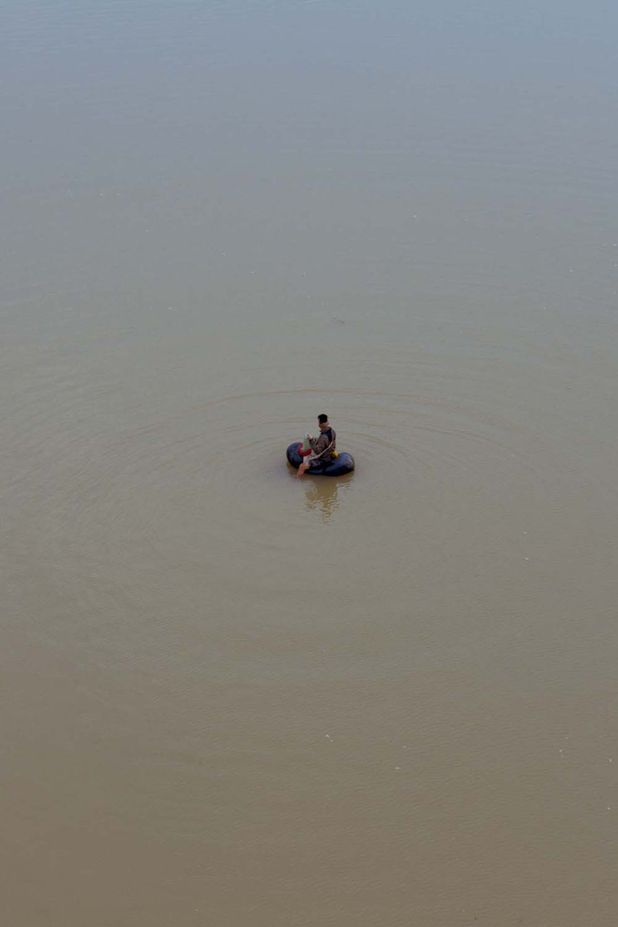 A fisher in the mekong with his tiny toy boat, Jinghong, China