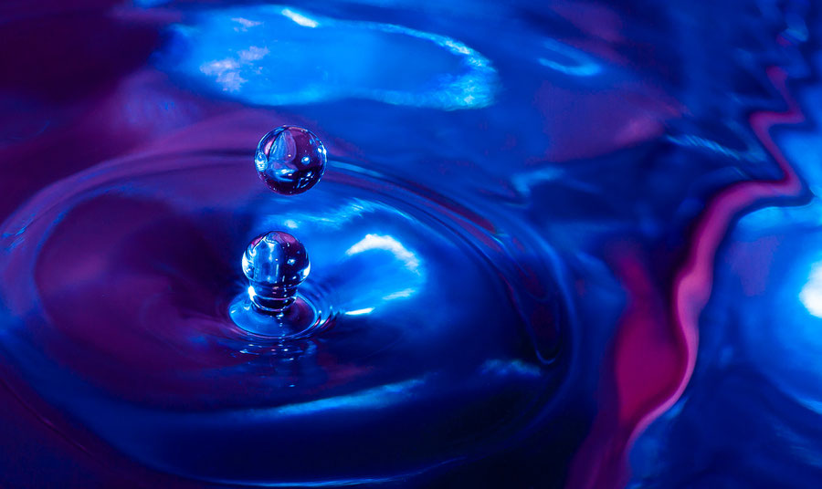 Liquid micro photography. Two drops are captured in the air dropping to the liquid.