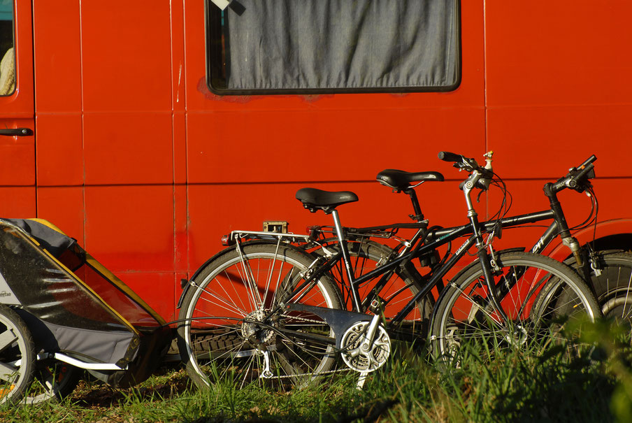 Zwei Fahrräder vor einem roten Wohnmobil