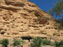 Mali. Das Dogonland. In der großen Felswand, der Falaise, wohnten früher die Dogon. Heute werden in den Höhlen die Verstorbenen bestattet.