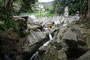 Karibikinsel Guadeloupe. Am Ende eines langen und schlammigen Wandertages kommt ein Wasserbecken zum Schuheputzen wie gerufen.