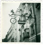 Schmiedeeisernes und vergoldetes Wirtsschild vom Gasthof "zur Post" in der Südtiroler Straße in Rattenberg, Bzk. Kufstein, Tirol. Gelatinesilberabzug ca. 6 x 6 cm (Amateuraufnahme) 1952.  Inv.-Nr. vu606gs00003