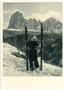 Skiläuferin vor der Bergkulisse der Langkofelgruppe in den Südtiroler Dolomiten nach dem Abschnallen der Skier. Gelatinesilberabzug 10 x 15 cm; ohne Impressum, um 1940.  Inv.-Nr. vu105gs00008