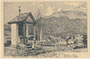 Kössen, Bezirk Kitzbühel, Tirol mit Pfarrkirche zu den Hll. Petrus und Paulus von Südosten, im Vordergrund ein Kapellenbildstock. Federstrichlithographie ohne Künstlersignatur und Verlagsimpressum, 1931 oder früher.  Inv.-Nr. vu914lg00003