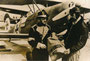 Postgutübergabe zwischen österreichischem Postbediensteten und reichsdeutschem Postflieger (v.l.n.r.). Gelatinesilberabzug 18 x 24 cm mit Datumstempel "Werbestelle 12. Apr. 1968" (wohl Repro eines Originals von etwa 1930).  Inv.-Nr. vu1824gs00001