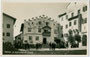 Plunerschneider-Haus (in Bildmitte) und der seit 1919 als Rathaus genutzte ehem. Ansitz Krausegg (rechts) am Marktplatz von Kastelruth. Gelatinesilberabzug 9 x 14 cm; Impressum: Foto Misinato, Seis am Schern um 1935.  Inv.-Nr. vu914gs00327