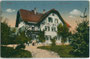 Hotel “Bahnhof” im Heimatstil  (heute Hotel “Linde”) mit Außenanlage vis à vis von Bahnhofsrestauration und Stationsgebäude (beide 1944 zerbombt) in Wörgl. Farblichtdruck 9 x 14 cm; Verlag Purger & Co., München um 1910.  Inv.-Nr. vu914fld00059