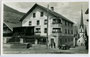 Steyr XII (Bauzeit 1925/29) beim Gasthof „zur Post“ am Georg-Matthäus-Vischer-Platz und Pfarrkirche St. Johannes Bapt. und Ev. in Wenns im Pitztal, Bzk. Imst, Tirol. Gelatinesilberabzug 9 x 14 cm ohne Urhebernachweis um 1930.  Inv.-Nr. vu914gs00091