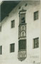 Zweigeschoßiger Fassadenerker der alten Volksschule in Wattens im Gerichtsbezirk und Bezirk Hall in Tirol. Gelatinesilberabzug 9 x 14 cm; Aufnahme und Verlag A(lfred). Stockhammer, Hall in Tirol 1911.  Inv.-Nr. vu914gs00792