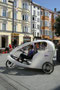 Mit elektrischer Anfahrhilfe ausgestattete, moderne chinesische Fahrradrikscha  für Lenker und zwei Passagiere oder Ladegut am Nordende der Maria-Theresien-Straße in Innsbruck. Digitalphoto; © Johann G. Mairhofer 2014.  Inv.-Nr. 2DSC00996