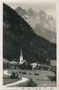 St. Jakob in Haus an der Pillerseetal Landesstraße (L2), Bzk. Kitzbühel, Tirol mit Pfarrkirche gegen Loferer und Leoganger Steinberge (AVE 9). Gelatinesilberabzug 9 x 14 cm; Impressum: Ad(olf). Künz, Anichstr. 32, Innsbruck um 1930.  Inv.-Nr. vu914gs01213