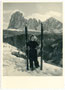 Skiläuferin vor der Bergkulisse der Langkofelgruppe in den Südtiroler Dolomiten nach dem Abschnallen der Skier. Gelatinesilberabzug 10 x 15 cm; ohne Impressum (wohl Amateuraufnahme), um 1940.  Inv.-Nr. vu105gs00008