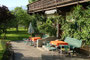 Baumbestandene Grünfläche und mit naturgespaltenen Schieferplatten ausgelegter Eingangsbereich mit Gartenmöbel der Pension "Rainhof" in Kitzbühel-Ölberg, Hornweg 17. Digitalphoto; © Johann G. Mairhofer 2015.  Inv.-Nr. 2DSC02532