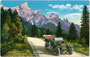 Automobil mit Chauffeur auf der Rollepassstraße vor der Palagruppe mit Cimon della Pala (3.184m) in den Dolomiten. Photochromdruck 9x14cm; Impressum: Joh(ann). F(ilibert). Amonn, Bozen um 1910.  Inv.-Nr. vu914pcd00211