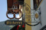 Schmiedeeisernes Geschäftsschild mit einer Bretze als Motiv der Bäckerei Neumayr, Josef-Herold-Straße 7 in der Bezirkshauptstadt Kitzbühel, Tirol,. Digitalphoto; © Johann G. Mairhofer 2015.  Inv.-Nr. 2DSC02842
