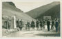 Österr. und ital. Zöllner am Grenzübergang Brenner gg. österr. Grenzstation, Gde. Gries von ital. Seite (Comune di Brennero) aufgenommen. Gelatinesilberabzug 9 x 14 cm; Impressum: Much Heiss, Alpiner Kunstverlag, Innsbruck um 1925.  Inv.-Nr. vu914gs01108