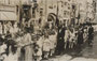 Fronleichnamsprozession der Stadtpfarre (heute Dompfarre) Innsbruck beim Gasthof „Goldener Adler“ in der Altstadt, Herzog-Friedrich-Straße 6. Gelatinesilberabzug 9 x 14 cm. Impressum Fritz Gratl, Photographie und Verlag, Innsbruck.  Inv.-Nr. vu914gs00224