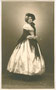 Junge Dame in biedermeierlichem Reifroch mit Schultertuch und Schute zu entsprechendem Anlass (z.B. Kostümfest, Jubiläum, Bühnenauftritt) eingekleidet. Gelatinesilberabzug 9 x 14 cm ohne Impressum, angeblich Lienz um 1935. Inv.-Nr. vu914gs00571