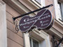 Geschäftsschild von Geigenbaumeister Georg Kozák an der Straßenfassade des Palais Wolkenstein in der Universitätsstraße neben den Innsbrucker Stadtsälen. Digitalphoto; © Johann G. Mairhofer 2012.  Inv.-Nr. 1DSC04347
