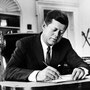 JFK travaillant dans son bureau de la Maison Blanche.