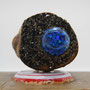 Seifenhalter made by lemmersens, Detailansicht Stirnseite mit blauem Resin-Cabochon und schwarzem Glitter, auf Seifentstück mit Kronkorken