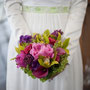 Luftiges Brautkleid aus Seidensatin und Seidenchiffon mit einem Taillenbündchen aus grünem Seidensatin mit Blütenstickereien überzogen. Dazu ein klassischer Bolero aus Stretch-Seidensatin