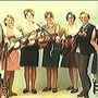 Willy Wissink en Anita Corelli poseren met een aantal van hun leerlingen van hun gitaarschool.