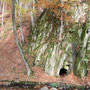 Sie sahen am Ende des Weges einen hohen Felsen, der mit seinem Grau aus dem Gelb-braun der Blätter hervorstach. Dann sahen sie das schwarze Loch unten am Felsen – die Höhle. 