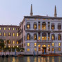 Das Aman Venice Hotel in abendlicher Stimmung mit erleuchteten Fenstern im letzten Tageslicht vom Canal Grande aus