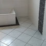Frise verticale en galets, à l'opposé du meuble vasque. Rappel de la frise au sol autour de la baignoire.