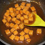 Tofuwürfel mit einem Schaumlöffel aus dem Rapsöl holen, in die Sauce geben und unterheben
