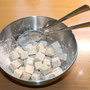 Tofuwürfel in die Schüssel geben und (z.B. mit 2 EL) unterheben, bis die Würfel gleichmäßig paniert sind