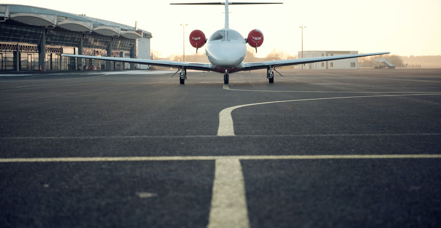 Ein Flugzeug steht vor einem Flughafengebäude. Bild von Marcus Zymmer auf Unsplash. 