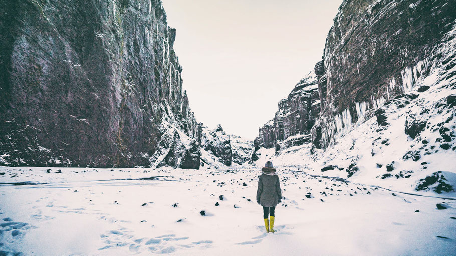 Frau steht in schneebedeckter Winterlandschaft. Foto von Jonatan Pie auf Unsplash.